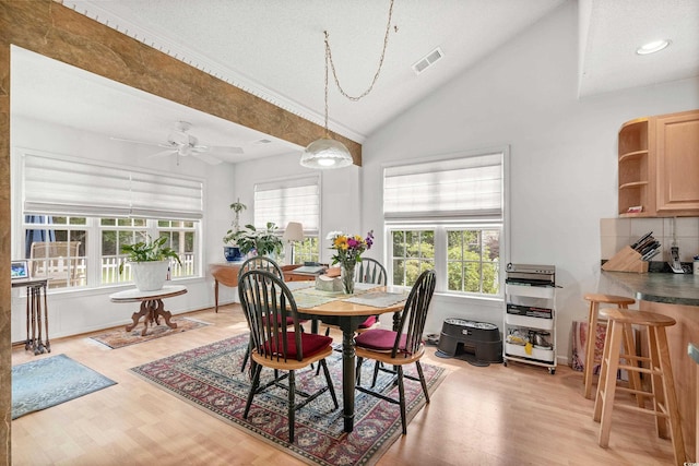 dining room with ceiling fan, high vaulted ceiling, and light hardwood / wood-style flooring