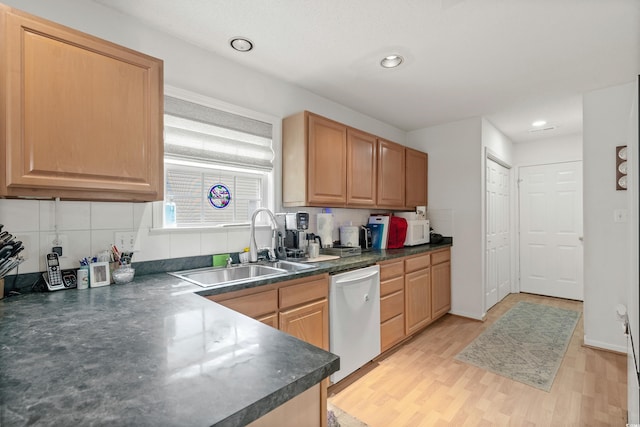 kitchen featuring sink, backsplash, light hardwood / wood-style floors, and white appliances