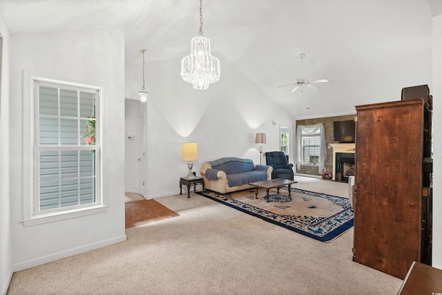 carpeted living room with vaulted ceiling and ceiling fan with notable chandelier