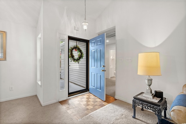 foyer entrance with light parquet flooring and high vaulted ceiling