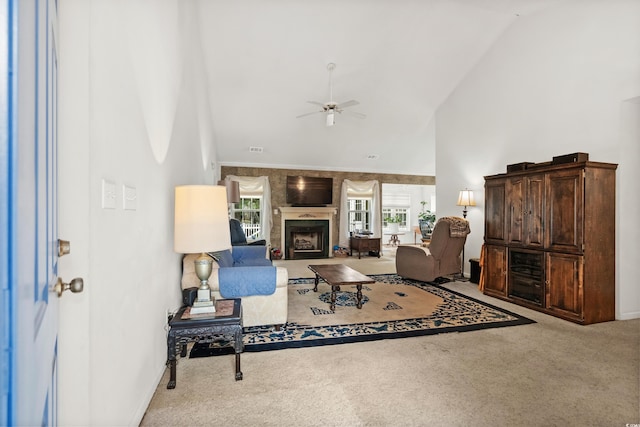 carpeted living room with ceiling fan and high vaulted ceiling