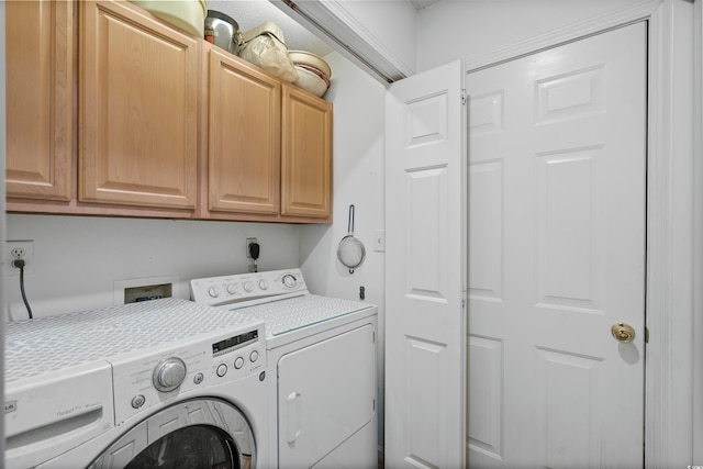 laundry room featuring washing machine and dryer and cabinets