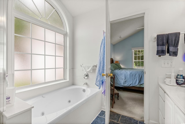 bathroom with vanity, tile patterned flooring, a textured ceiling, vaulted ceiling, and a bathtub