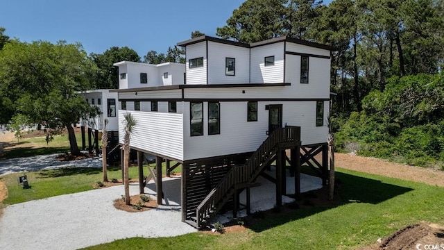 216 Brown Pelican Loop, Pawleys Island, SC 29585 - back of house featuring stairway, a carport, a yard, and view of scattered trees