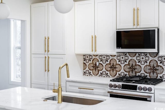 216 Brown Pelican Loop, Pawleys Island, SC 29585 - kitchen featuring stainless steel gas range oven, a sink, white cabinetry, and decorative backsplash