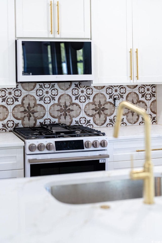 room details featuring tasteful backsplash, stainless steel range with gas cooktop, and light countertops