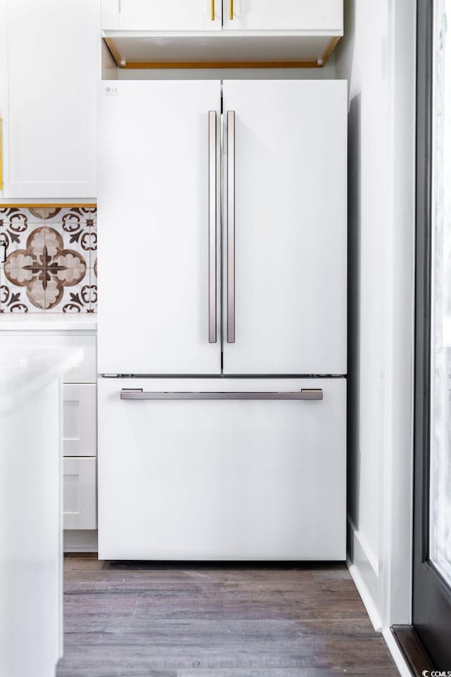 details with white cabinetry, light countertops, wood finished floors, and freestanding refrigerator