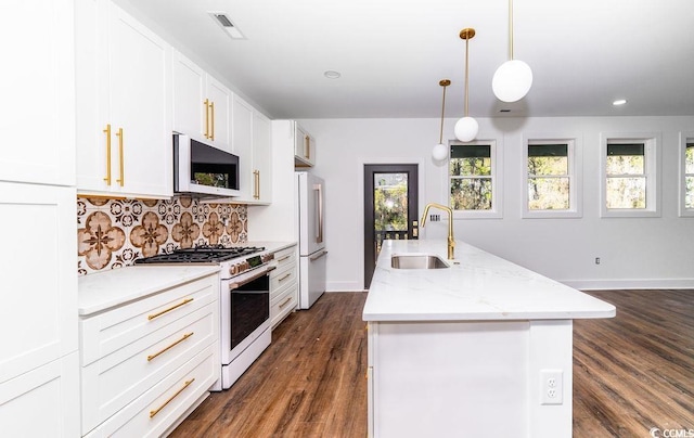 216 Brown Pelican Loop, Pawleys Island, SC 29585 - kitchen with range with gas cooktop, a sink, white fridge, decorative backsplash, and a kitchen island with sink