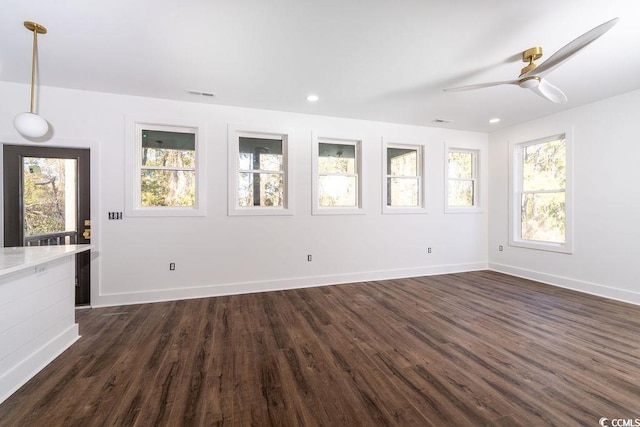 unfurnished living room with dark wood-style floors, baseboards, and a ceiling fan