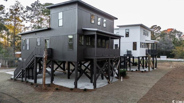 back of house featuring a patio, stairway, and a sunroom