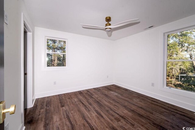 interior space featuring dark wood finished floors, multiple windows, baseboards, and ceiling fan