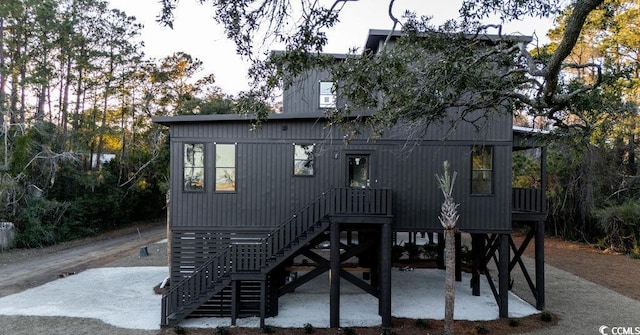 rear view of property with stairs and a patio area