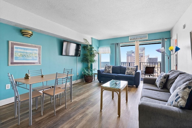 living area with a textured ceiling, baseboards, and wood finished floors