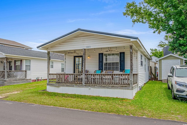 view of front of home with an outdoor structure, a front yard, and covered porch