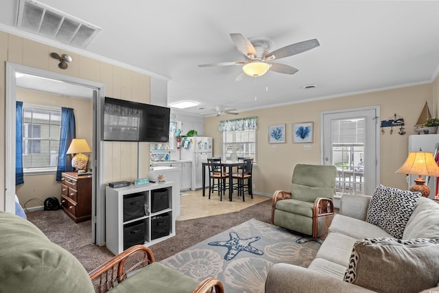 carpeted living room featuring crown molding and ceiling fan