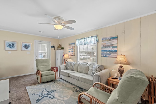 carpeted living room featuring ornamental molding and ceiling fan