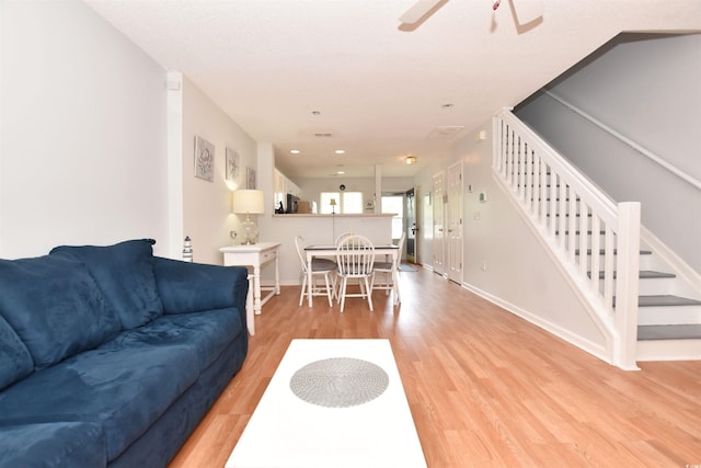 living room featuring ceiling fan and light wood-type flooring