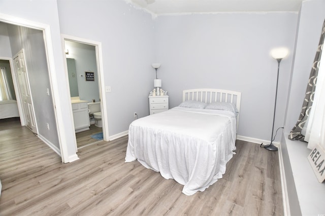 bedroom featuring light hardwood / wood-style floors and ensuite bathroom