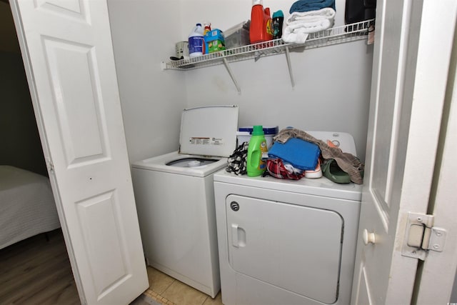 laundry room featuring washing machine and dryer and light tile patterned floors