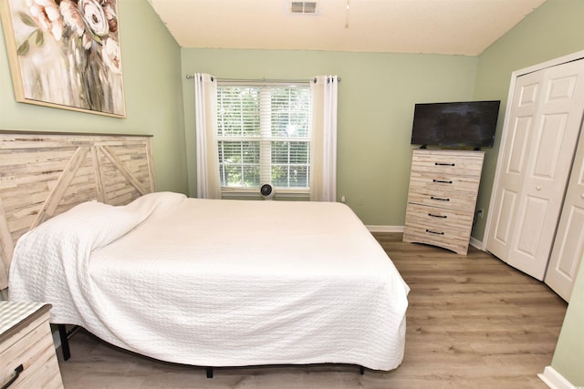 bedroom with light hardwood / wood-style flooring and a closet