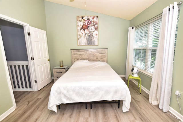 bedroom with light hardwood / wood-style floors and vaulted ceiling