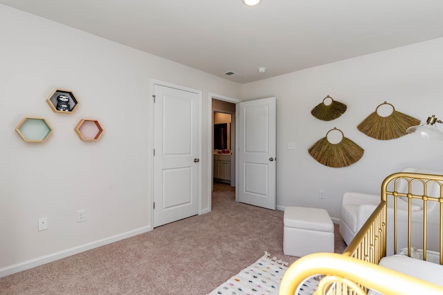 carpeted bedroom featuring a nursery area