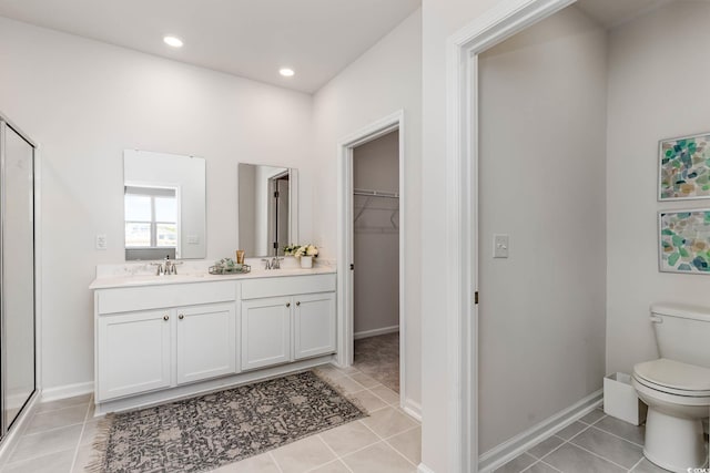 bathroom featuring walk in shower, vanity, toilet, and tile patterned flooring