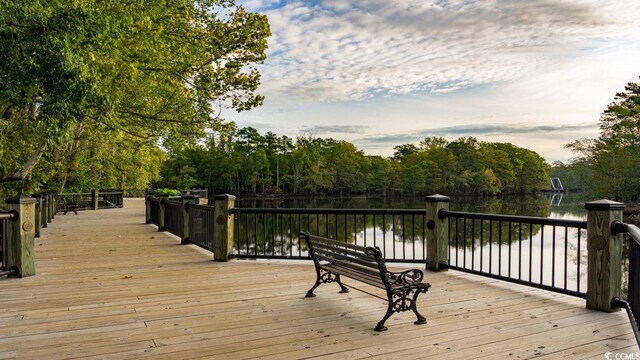 deck at dusk featuring a water view