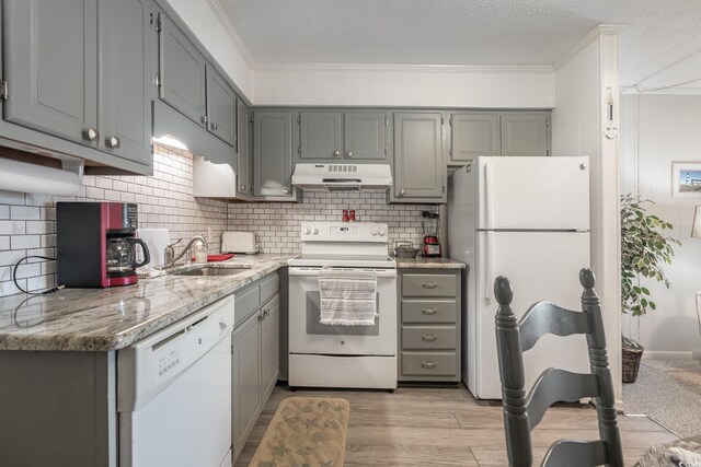 kitchen featuring sink, light wood-type flooring, white appliances, and gray cabinets