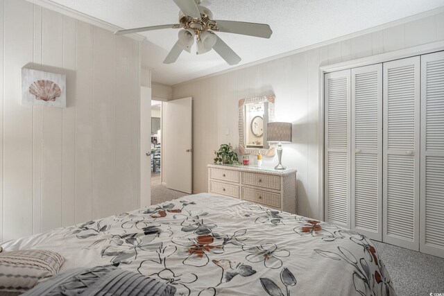 bedroom with a textured ceiling, carpet floors, ceiling fan, and a closet