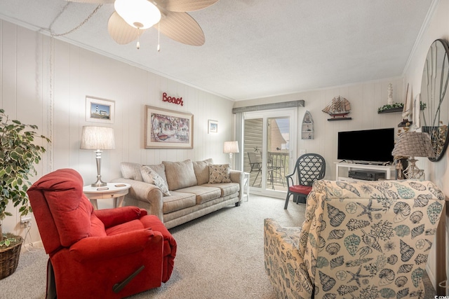 living room with a textured ceiling, carpet floors, ornamental molding, and a ceiling fan