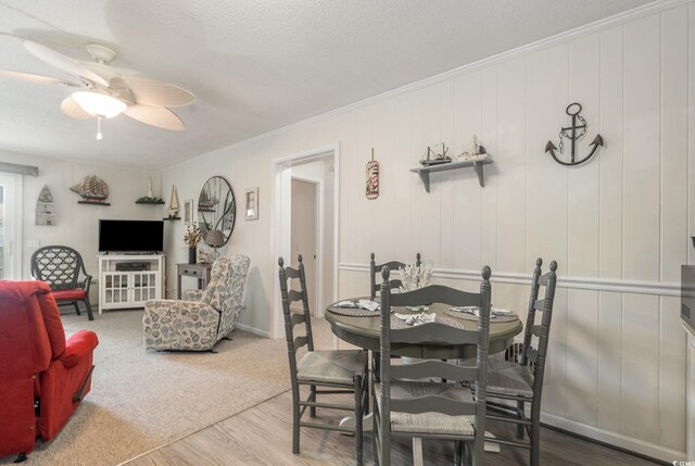 dining room with ceiling fan, wood-type flooring, and a textured ceiling