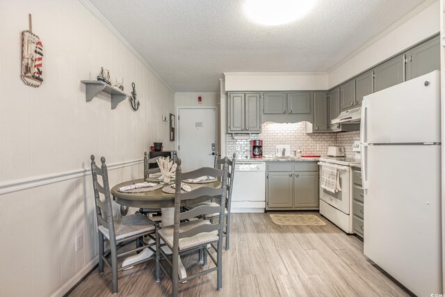 kitchen with backsplash, light hardwood / wood-style flooring, white appliances, a textured ceiling, and gray cabinets