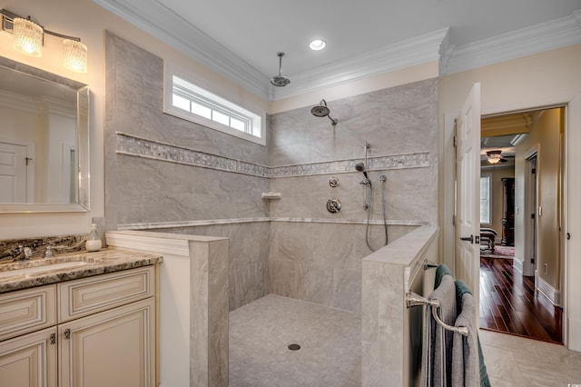 bathroom with a tile shower, crown molding, hardwood / wood-style floors, and vanity