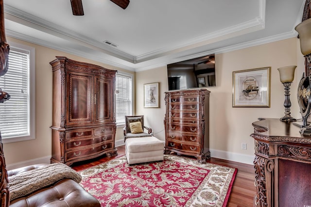 living area featuring crown molding, ceiling fan, and wood-type flooring