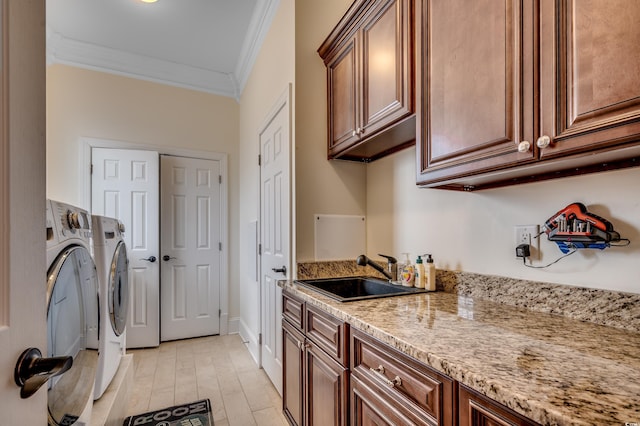 clothes washing area with cabinets, sink, crown molding, light hardwood / wood-style flooring, and independent washer and dryer