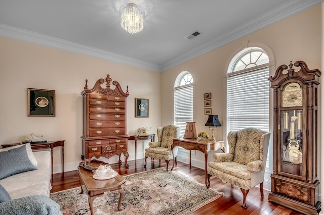 sitting room with hardwood / wood-style flooring, an inviting chandelier, and ornamental molding