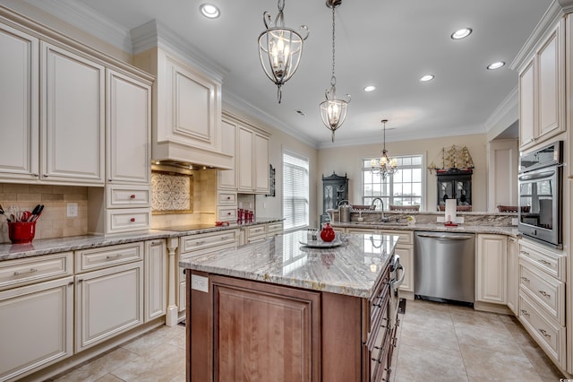 kitchen featuring a chandelier, appliances with stainless steel finishes, a center island, and hanging light fixtures