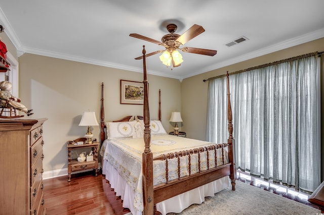 bedroom with hardwood / wood-style flooring, ceiling fan, and crown molding