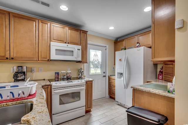 kitchen with white appliances, light stone counters, and crown molding