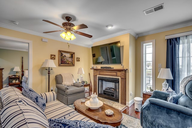 living room featuring hardwood / wood-style floors, ceiling fan, and crown molding