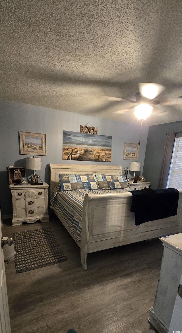 bedroom featuring ceiling fan, dark hardwood / wood-style floors, and a textured ceiling