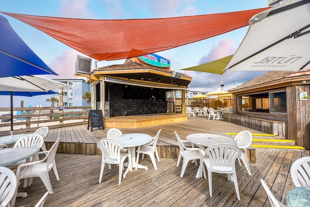 deck at dusk featuring a bar