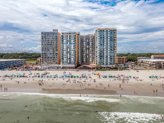 birds eye view of property with a water view and a beach view