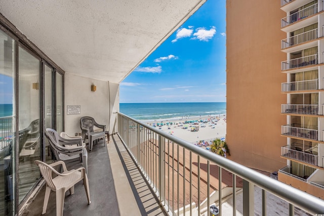 balcony featuring a water view and a beach view