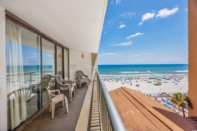 balcony featuring a beach view and a water view