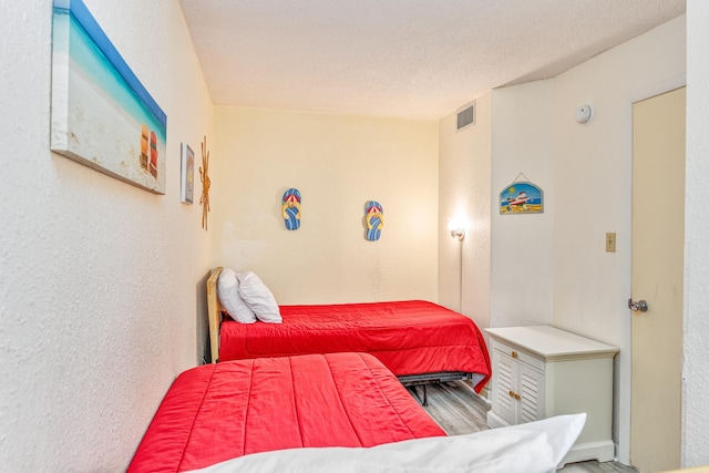 bedroom with hardwood / wood-style flooring and a textured ceiling