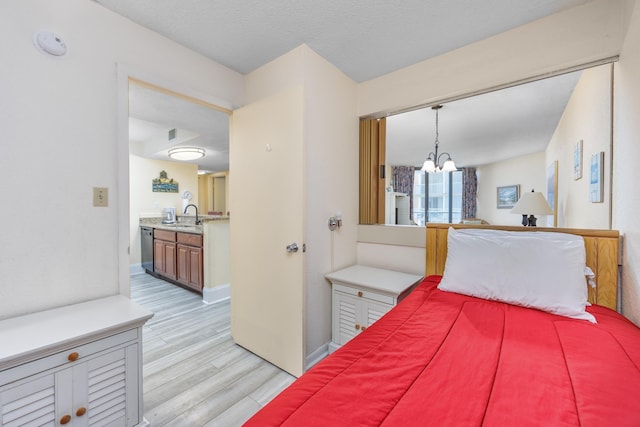 bedroom featuring sink, a notable chandelier, and light hardwood / wood-style floors