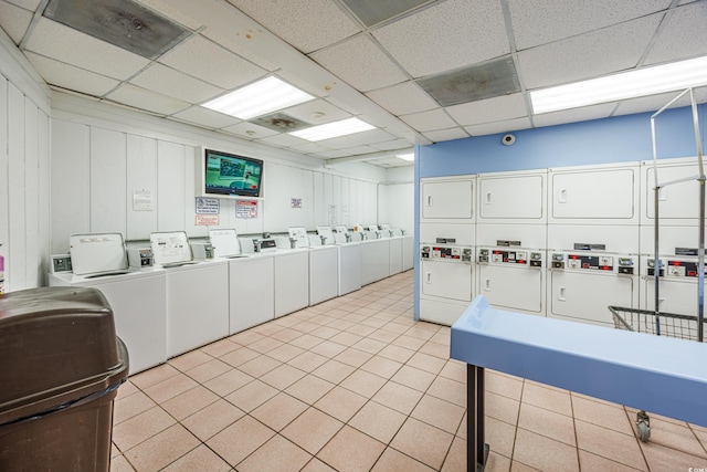 kitchen featuring stacked washing maching and dryer, a paneled ceiling, white cabinetry, and washer and clothes dryer