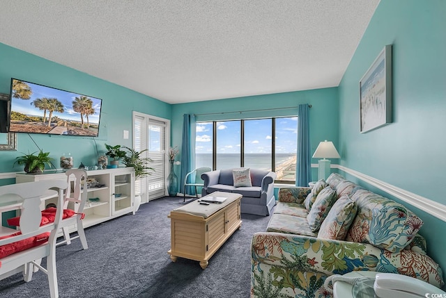 carpeted living room with a water view and a textured ceiling